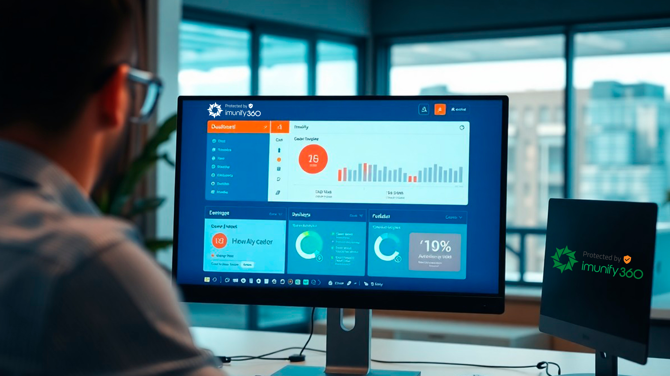 Una persona observa la pantalla de una computadora que muestra el panel de Imunify 360 con gráficos y datos detallados. Junto al monitor, una laptop luce con orgullo el logotipo de Imunify 360. El entorno de oficina, enmarcado por amplios ventanales, transmite una sensación de amplitud y concentración.